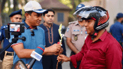 হেলমেট পরা মোটরসাইকেল আরোহীদের ফুল দিচ্ছেন কিশোরগঞ্জের এসপি
